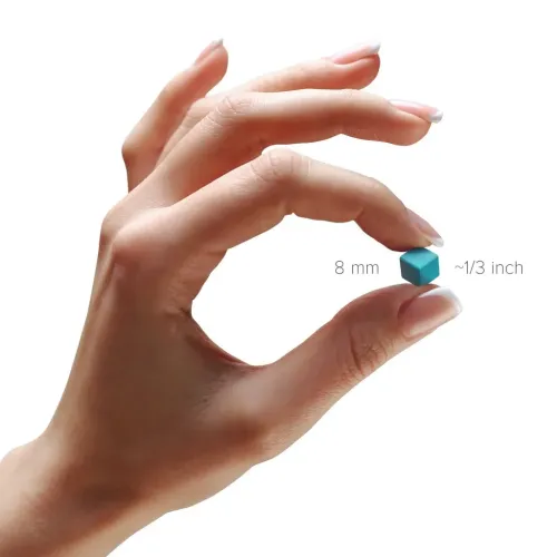 Turquoise cube-shaped building block held between thumb and forefinger against white background, with text showing 8 mm (~1/3 inch) next to the cube.