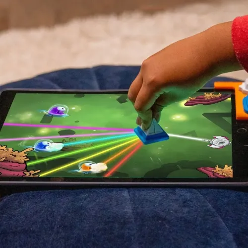 Play Shifu Tacto: Laser på surfplatta; barnhand styr blått prismastycke som delar laserstrålar, med ramklämma vid kanten.